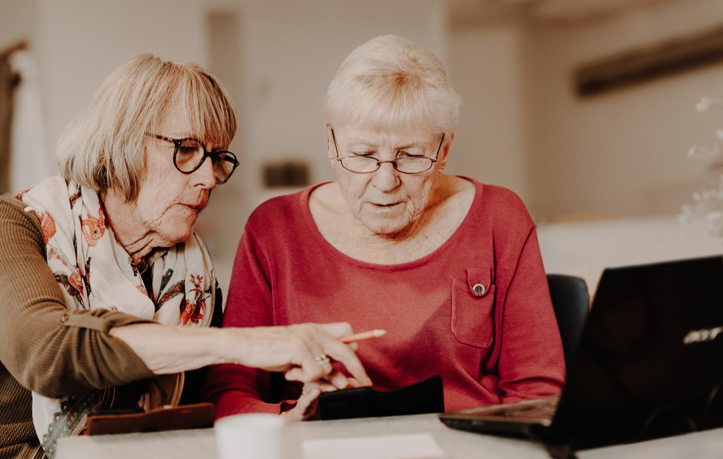 Eldre kvinner ser på tablet sammen